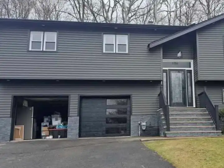Split-level house with new gray siding and front steps