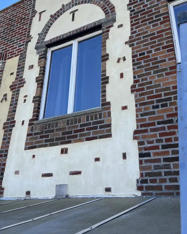 Brick facade with window openings being restored