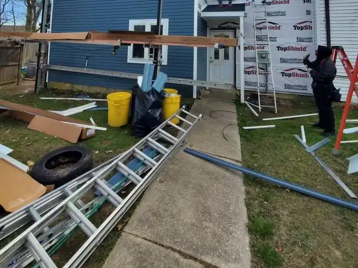 Crew installing new blue siding on a two-story house
